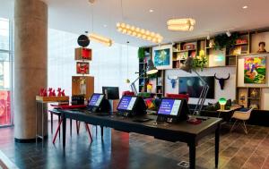 um quarto com uma mesa com computadores portáteis em citizenM Austin Downtown em Austin