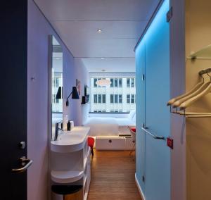 a bathroom with a sink and a bed in a room at citizenM Austin Downtown in Austin