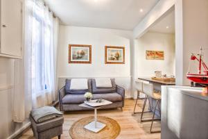 sala de estar con sofá y mesa en La Maison de Pêcheur de Ginette en Cabourg