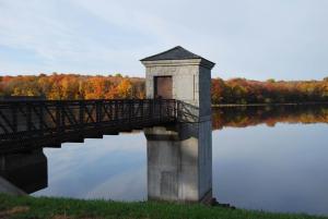 a bridge over a body of water with trees at Maron Hotel & Suites in Danbury