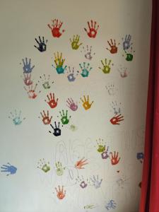 a wall with lots of handprints painted on it at Nature Villa in Rishīkesh