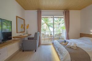 a bedroom with a bed and a television and a balcony at BIDONG VIEW RESORT in Kuala Terengganu