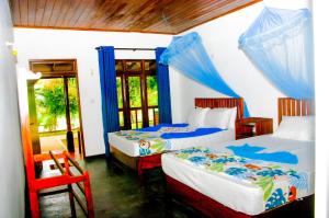 a bedroom with two beds and a chair in it at Pride Rock Villa in Sigiriya