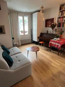 a living room with a couch and a piano at Montmartre Bright & Quiet in Paris