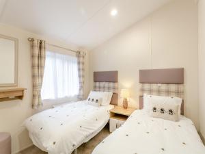 a bedroom with two beds and a window at Roseberry Topping - Uk42937 in Great Broughton