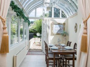 uma sala de jantar com um tecto arqueado e uma mesa e cadeiras em Royal Crescent Apartment em Bath