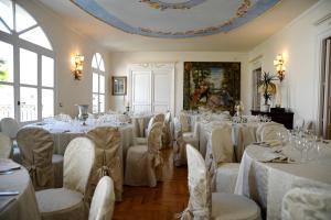 una habitación llena de mesas y sillas con manteles blancos en Corte Cristina & Suites, en Quartucciu
