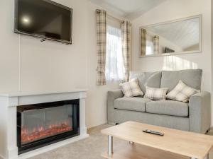 a living room with a couch and a fireplace at Wainstones Rocks - Uk42938 in Great Broughton