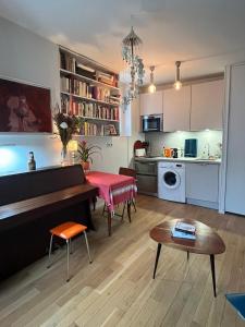 a living room with a piano and a kitchen at Montmartre Bright & Quiet in Paris