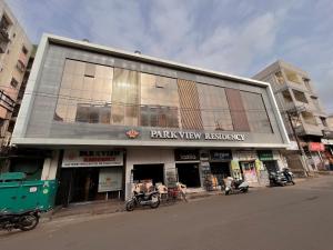 普杰StayGuru Park View Residency的街道边的一座建筑,摩托车停在外面