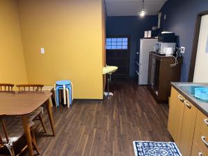 a kitchen with a table and chairs and a refrigerator at Shohakuen in Takayama