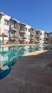 a swimming pool in front of a apartment building at Appartement El jadida Sidi Bouzid in Sidi Bouzid