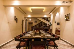 a dining room with a long table and a staircase at EKOSTAY - Polaris Villa in Majorda