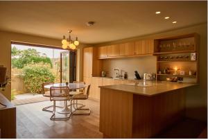 a kitchen with a counter and a table with chairs at Cromer Luxury Palm Springs Bungalow with Pool Room in Overstrand