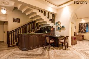 a living room with a staircase with a table and chairs at EKOSTAY - Polaris Villa in Majorda