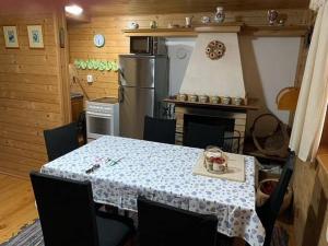 a kitchen with a table and a stove and a refrigerator at Útulná chata na horách in Valašské Klobouky