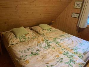 a large bed in a wooden room with a bedspread and pillows at Útulná chata na horách in Valašské Klobouky