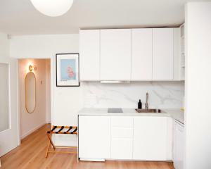 uma cozinha com armários brancos e um lavatório em Le 6 - Appartement douillet strasbourgeois avec terrasse em Estrasburgo