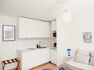 uma cozinha branca com armários brancos e um lavatório em Le 6 - Appartement douillet strasbourgeois avec terrasse em Estrasburgo