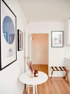 uma sala de estar com uma mesa branca e uma imagem na parede em Le 6 - Appartement douillet strasbourgeois avec terrasse em Estrasburgo