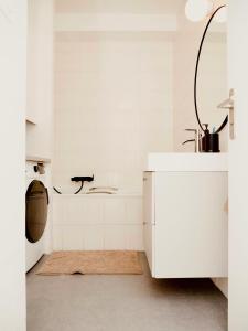 a white kitchen with a sink and a washing machine at Le 6 - Appartement douillet strasbourgeois avec terrasse in Strasbourg