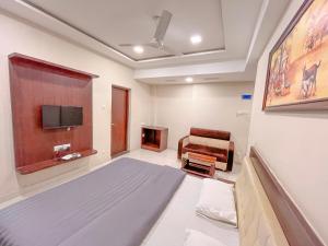 um quarto com uma cama, uma televisão e um sofá em Park View Residency em Bhuj