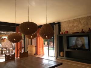 sala de estar con mesa, TV y lámparas de araña en Villa 202 commentaires 5 étoiles sur 3 sites, en Essaouira
