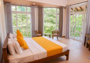 um quarto com uma cama grande e janelas em Roberosia - Holiday Home em Kandy