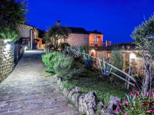 un sentiero in pietra che conduce a una casa di notte di Gorgeous Apartment with Pool near Sibillini Mountains a Monte San Martino