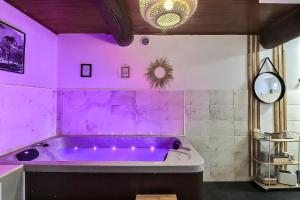 - une salle de bains pourpre pourvue d'une baignoire pourpre dans l'établissement Lâcher-prise SPA, à Bouillargues