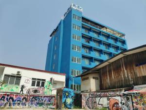 un bâtiment bleu avec graffiti devant deux bâtiments dans l'établissement Chevasai Hua Hin, à Hua Hin