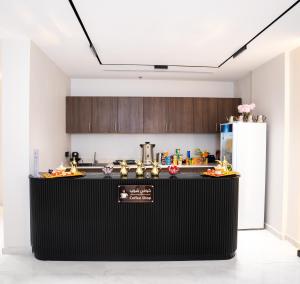 eine Küche mit einer schwarzen Theke und einem Kühlschrank in der Unterkunft فندق كنانة العزيزية من سما in Mekka