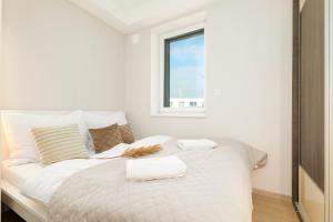 1 dormitorio con 1 cama blanca y 2 toallas en HomeAwayHome by the River, en České Budějovice