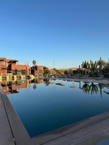 een grote plas water met gebouwen op de achtergrond bij Fellah Hotel in Marrakesh