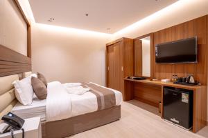 um quarto de hotel com uma cama e uma televisão de ecrã plano em فندق كنانة العزيزية من سما em Meca