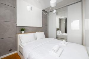 a bedroom with a white bed with two towels on it at Raginisa Chic Apartment in Szczecin
