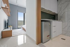 a kitchen with a refrigerator and a bedroom at Peaceful Studio - Wpool - Gym in Dubai