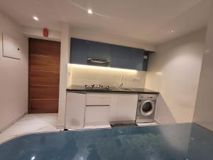 a kitchen with a sink and a washing machine at Gangothrii in Trivandrum