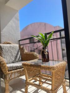 una mesa de cristal con una planta en un jarrón en un balcón en The Premier Suite, en Pusok