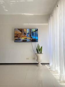 a living room with a tv on the wall and a plant at The Premier Suite in Pusok