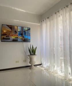 um quarto branco com uma planta num vaso ao lado de uma janela em The Premier Suite em Pusok