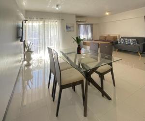 a dining room and living room with a glass table and chairs at The Premier Suite in Pusok