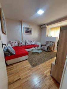 a living room with a red couch and a table at Apartment Vuk in Podgorica