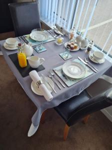 a grey table with plates and utensils on it at Brookside Guest House & Mini Spa in Brixham