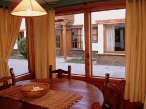 comedor con mesa y ventana grande en Apart Manantial del Valle en San Martín de los Andes