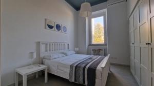 a white bedroom with a bed and a window at La casa dei Capperi - The house of capers 1 in Acireale