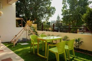 d'une terrasse avec une table et des chaises sur gazon. dans l'établissement The Basera, à Rishikesh
