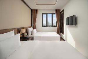 a hotel room with a bed and a television at Palazzo Boutique Hotel in Danang