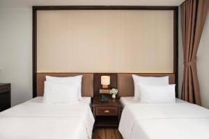 two beds sitting next to each other in a hotel room at Palazzo Boutique Hotel in Danang