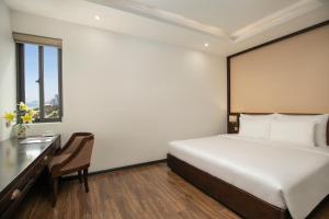 a hotel room with a bed and a desk at Palazzo Boutique Hotel in Danang